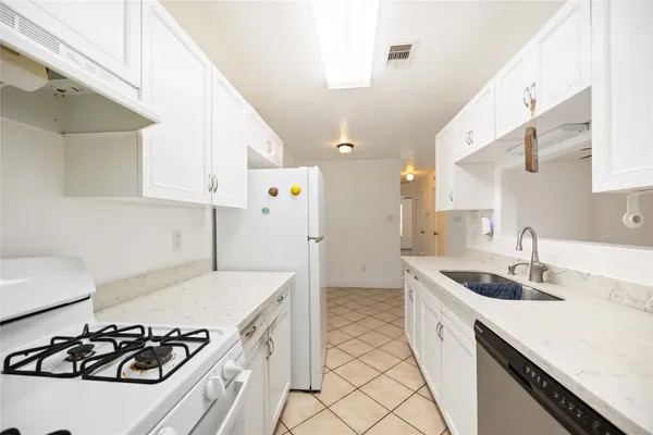 a kitchen with a sink a stove and cabinets