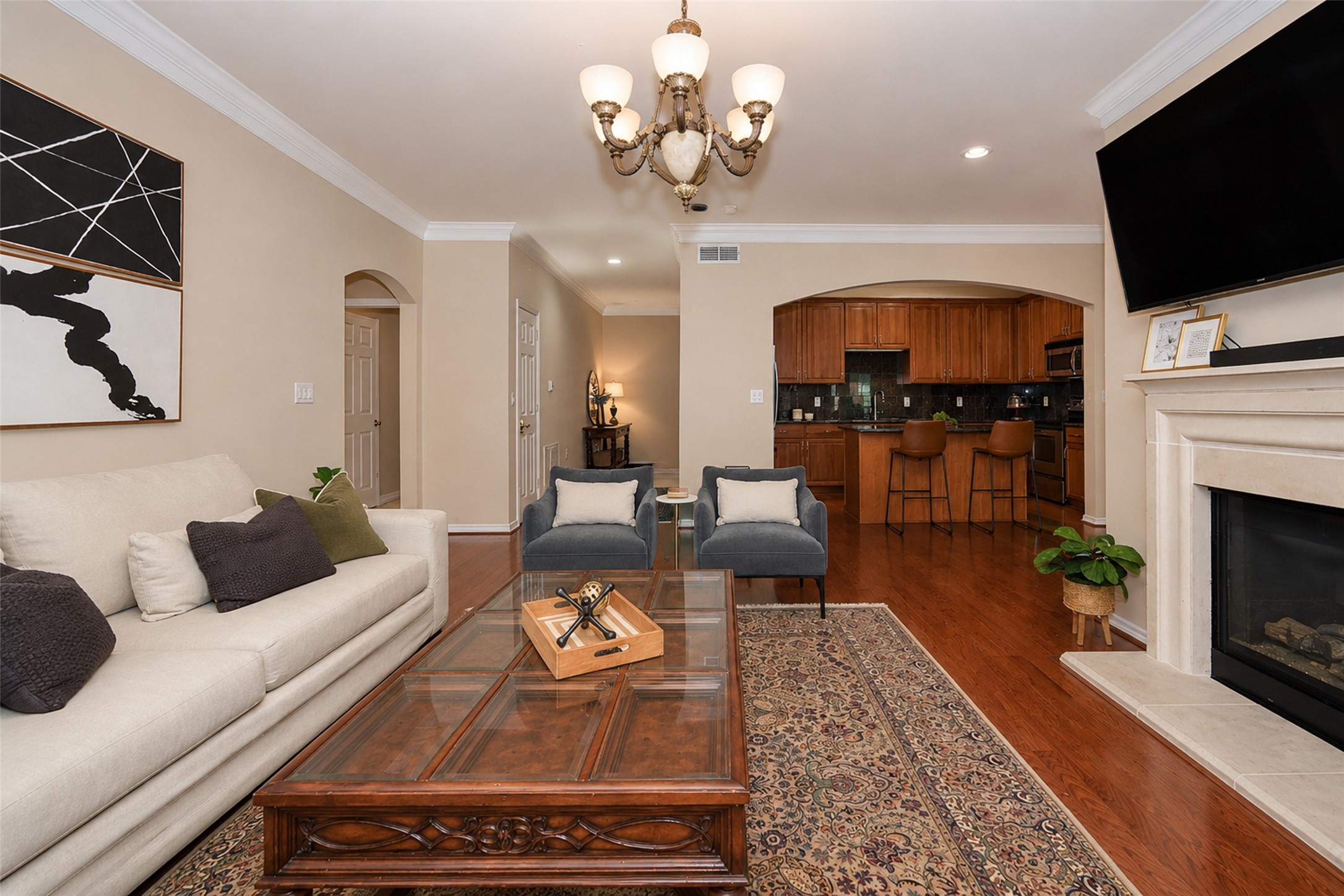 2400 McCue Road, Unit 401 Houston, TX 77056 - Photo 9 of 47 Spacious living room with fireplace. Room is bathed in natural light. Glass doors open to covered balcony with view of water feature. Home is fully furnished.