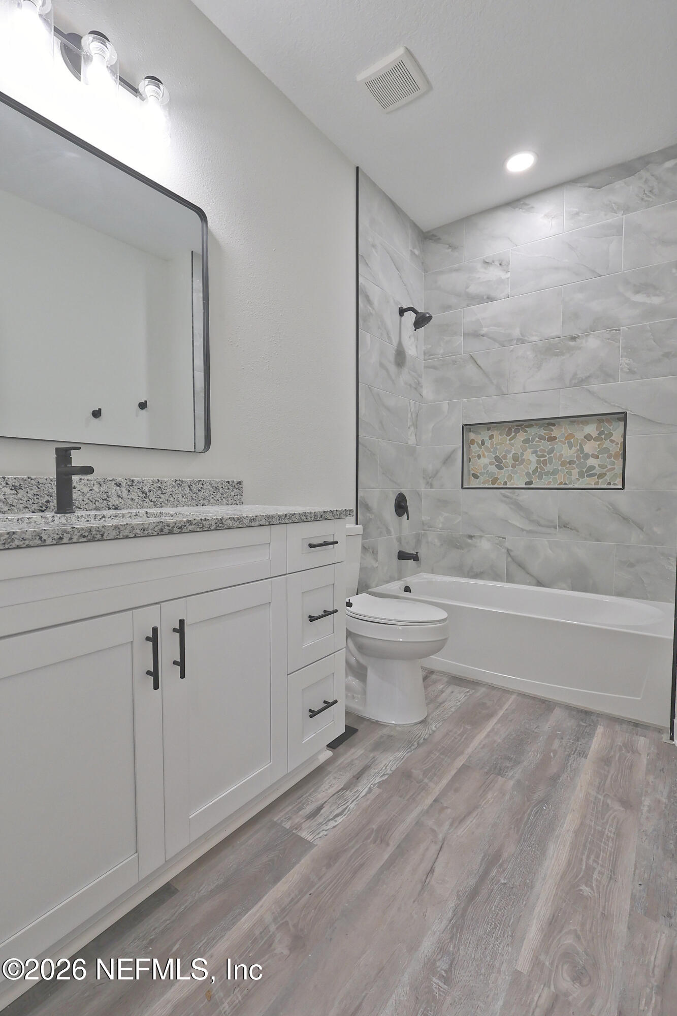 30 Delmonte Street Baldwin, FL 32234 - Photo 28 of 37 a spacious bathroom with a granite countertop sink a toilet and mirror