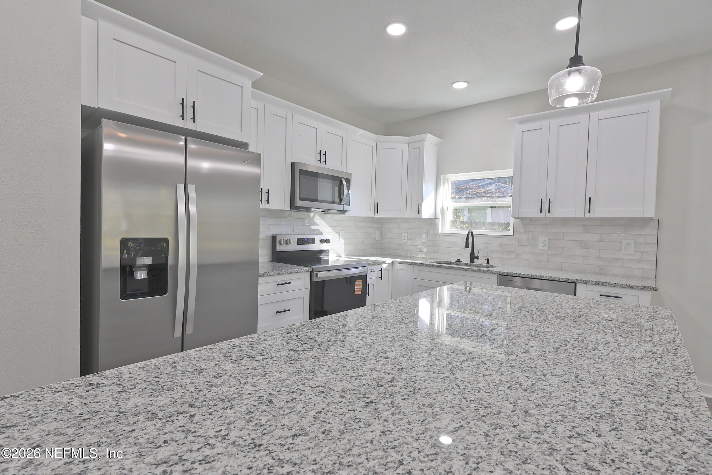 30 Delmonte Street Baldwin, FL 32234 - Photo 8 of 37 a kitchen with granite countertop a refrigerator sink and cabinets