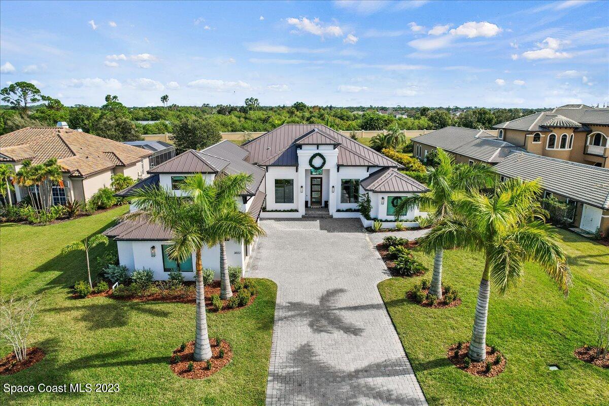 an aerial view of residential houses with outdoor space and trees