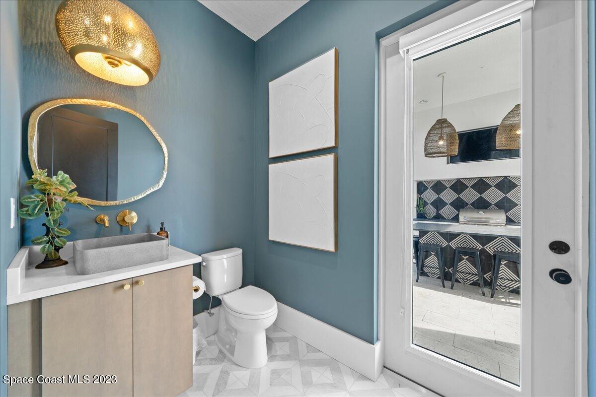 3022 BELLWIND Circle Rockledge, FL 32955 - Photo 23 of 46 a bathroom with a toilet sink vanity and mirror