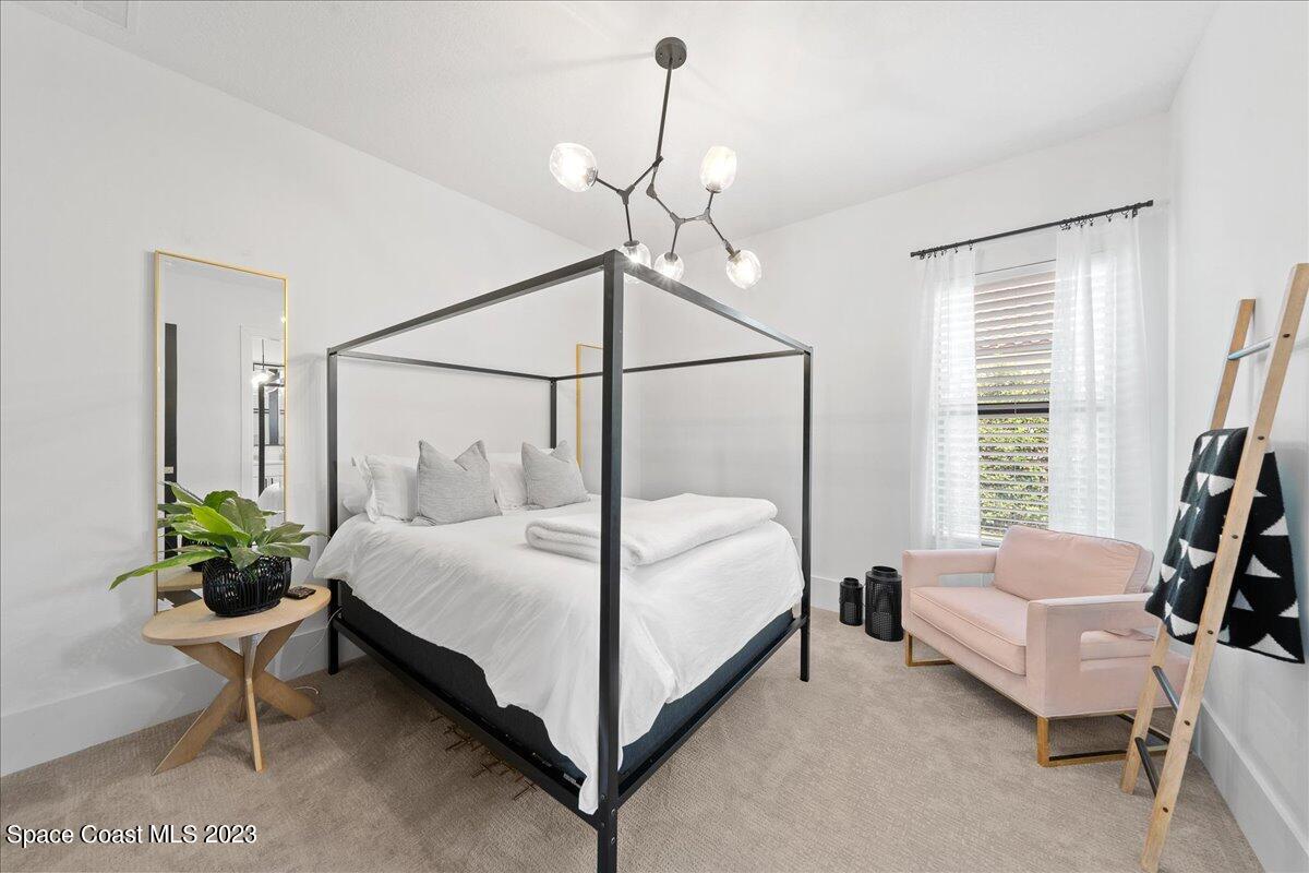 3022 BELLWIND Circle Rockledge, FL 32955 - Photo 24 of 46 a bedroom with a bed and a chandelier