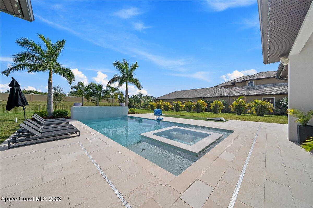3022 BELLWIND Circle Rockledge, FL 32955 - Photo 41 of 46 a view of a swimming pool with a garden and trees