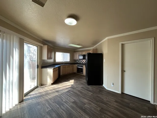 a view of a kitchen with refrigerator and a stove