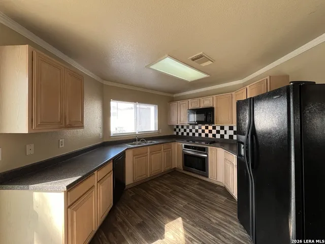 a kitchen with granite countertop stainless steel appliances and wooden cabinets