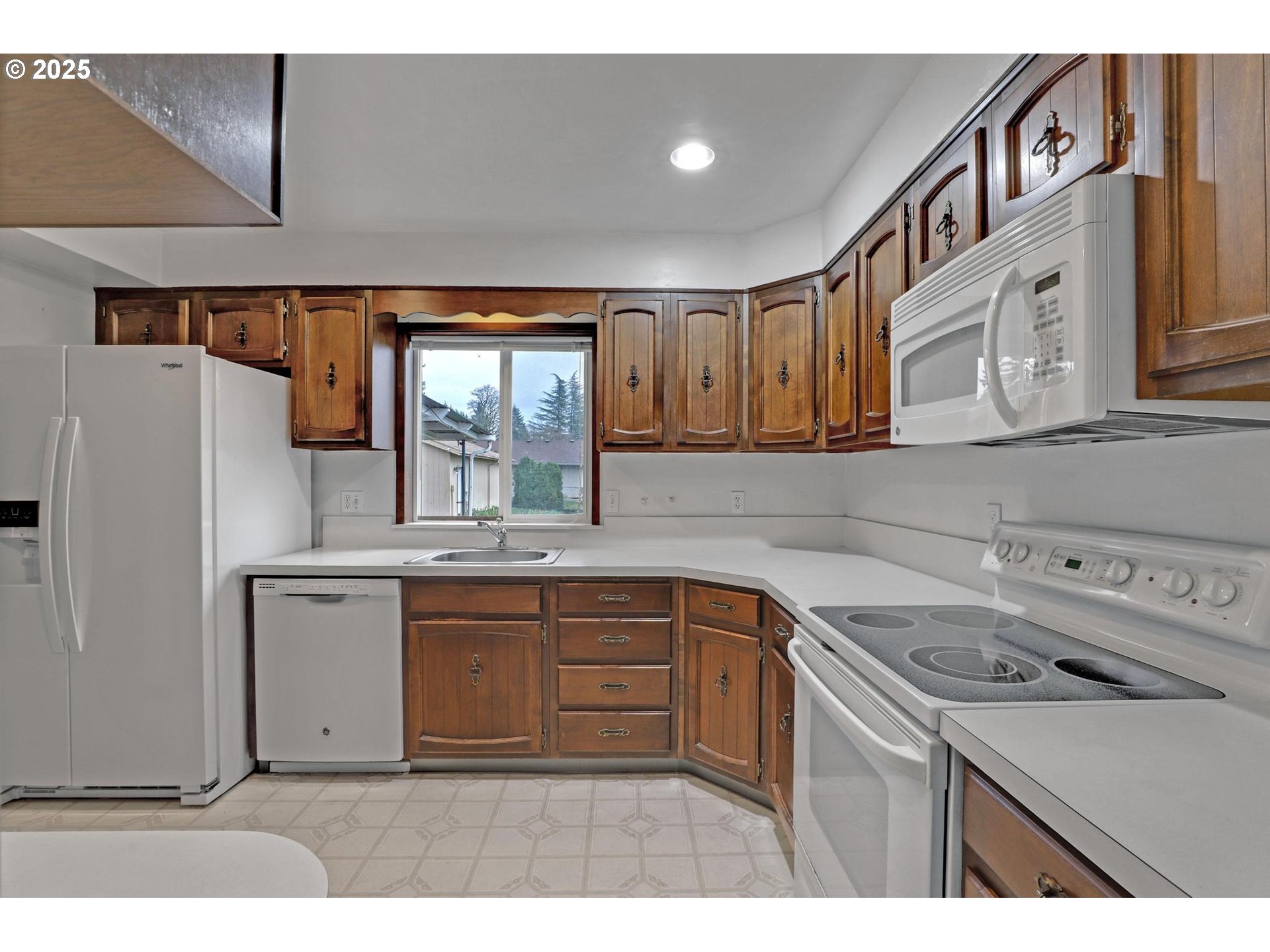 11500 Southwest 90th Avenue Portland, OR 97223 - Photo 7 of 30 a kitchen with a sink a stove a refrigerator and cabinets
