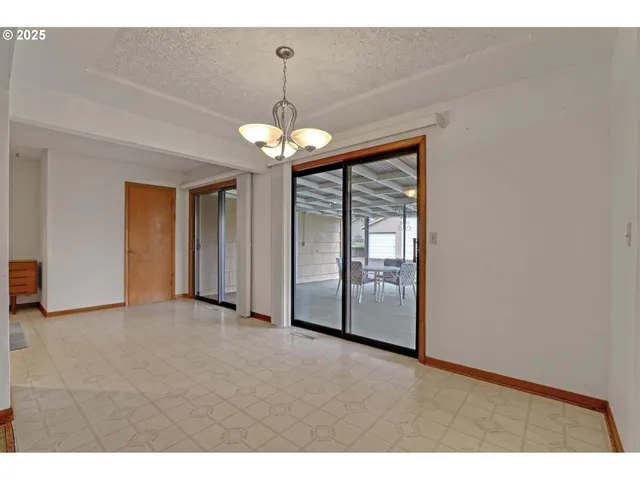 a view of a livingroom with a chandelier fan and windows