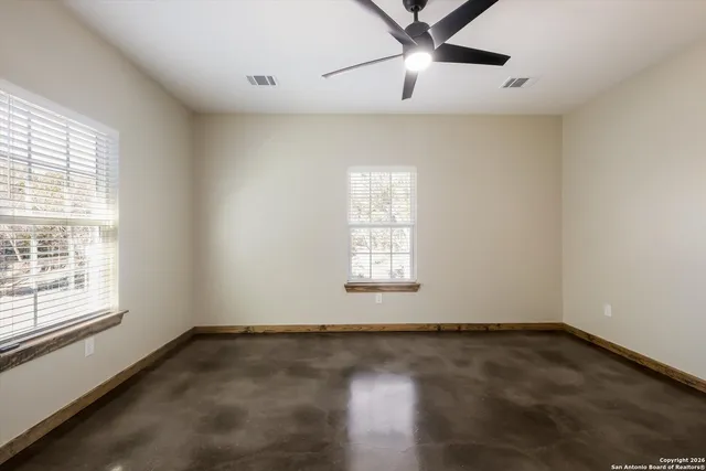a view of a big room with wooden floor and windows