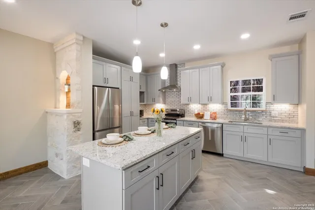 a view of an empty room with a kitchen and a window
