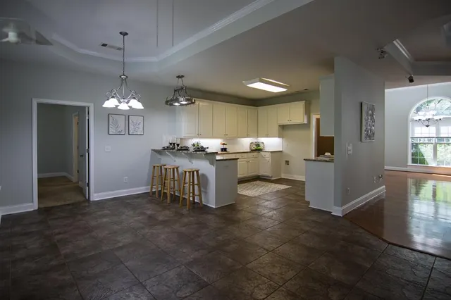 a kitchen with a dining table chairs refrigerator and cabinets