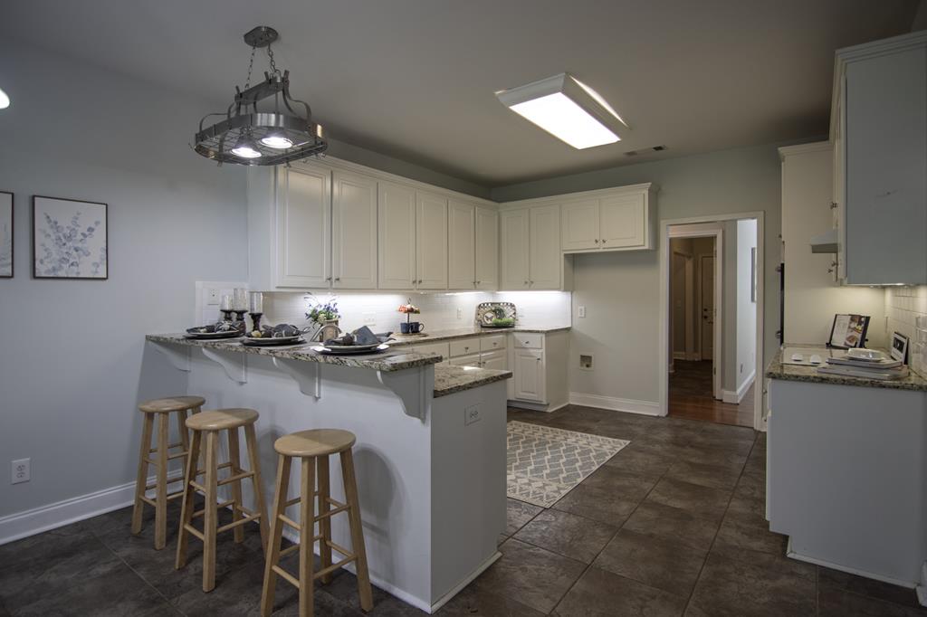 60 Roseanne Loop Hamilton, GA 31811 - Photo 19 of 54 a kitchen with a dining table chairs refrigerator and cabinets
