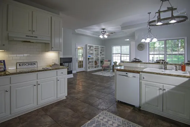 a kitchen with granite countertop white cabinets and stainless steel appliances