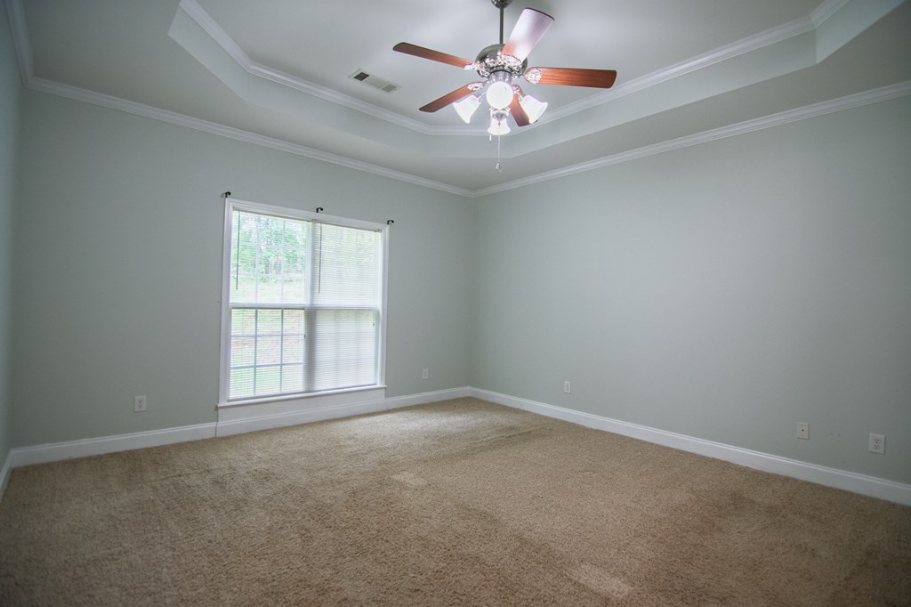 60 Roseanne Loop Hamilton, GA 31811 - Photo 26 of 54 an empty room with chandelier fan and windows