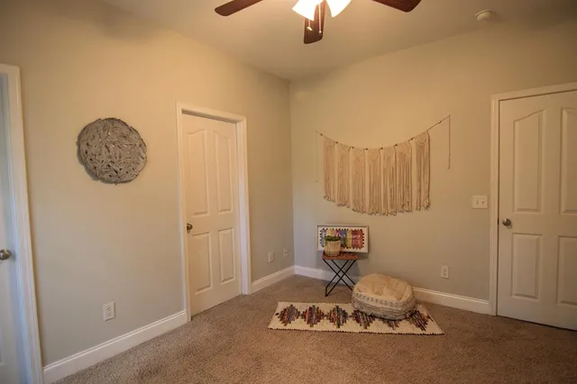 a view of room with windows and ceiling fan