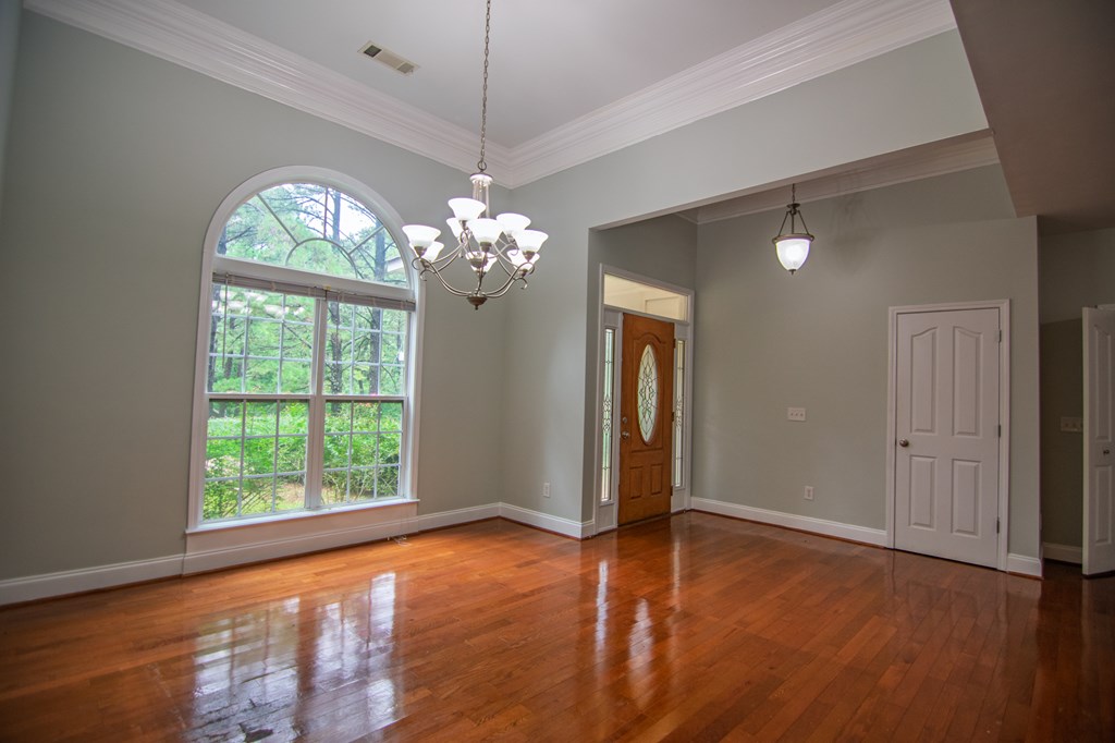 60 Roseanne Loop Hamilton, GA 31811 - Photo 10 of 54 an empty room with wooden floor chandelier and windows
