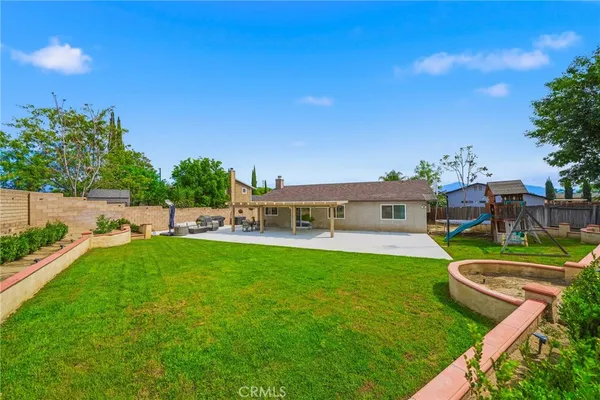 a view of a house with backyard sitting area and garden