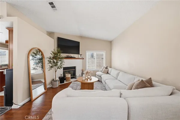 a living room with furniture a fireplace and a flat screen tv