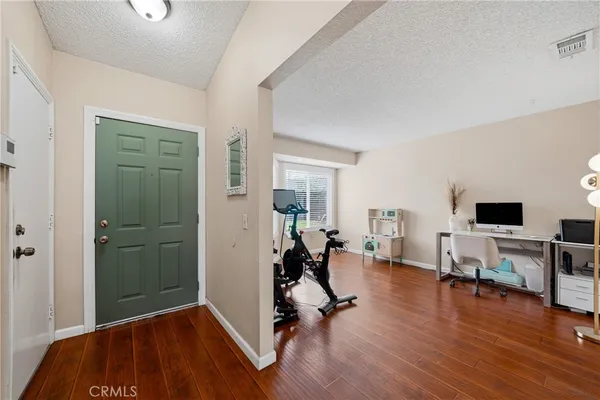 a view of a livingroom with hardwood floor and a workspace