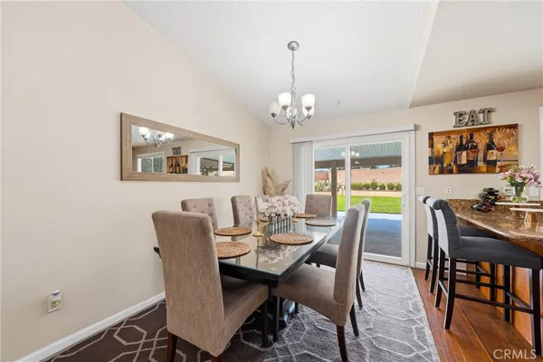 a view of a dining room with furniture a chandelier and wooden floor