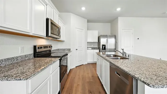 a kitchen with stainless steel appliances granite countertop a sink stove and refrigerator