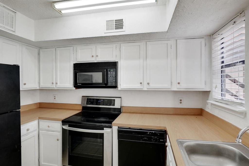 9821 Walnut Street, Unit 204 Dallas, TX 75243 - Photo 13 of 32 a kitchen with a stove and a microwave