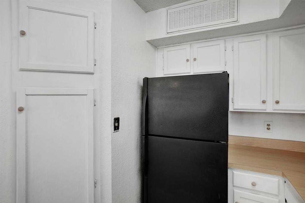 9821 Walnut Street, Unit 204 Dallas, TX 75243 - Photo 14 of 32 a view of a kitchen with refrigerator and cabinet