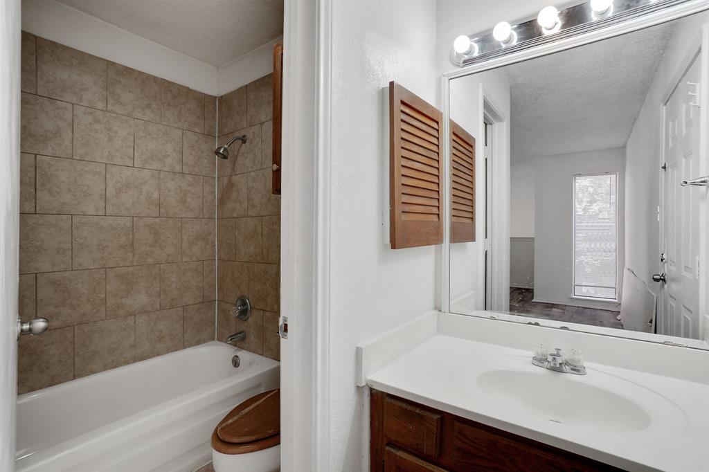 9821 Walnut Street, Unit 204 Dallas, TX 75243 - Photo 29 of 32 a bathroom with a bathtub shower sink vanity and a toilet