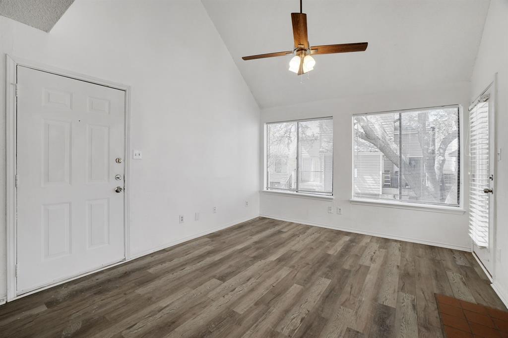 9821 Walnut Street, Unit 204 Dallas, TX 75243 - Photo 7 of 32 an empty room with wooden floor fan and windows