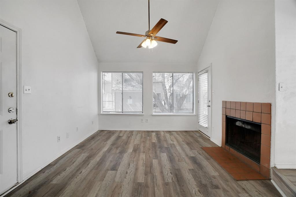 9821 Walnut Street, Unit 204 Dallas, TX 75243 - Photo 8 of 32 an empty room with wooden floor a fireplace and windows