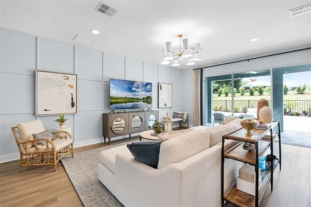 a living room with furniture a flat screen tv and a large window