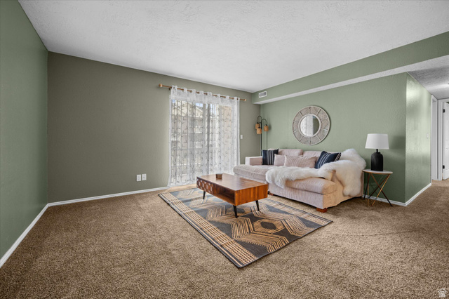 2095 South Main Street, Unit 13 Bountiful, UT 84010 - Photo 5 of 45 Carpeted living room with a textured ceiling and baseboards