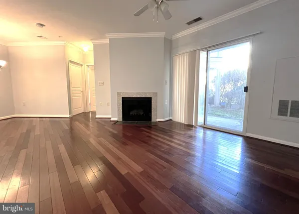 a view of empty room with wooden floor and fireplace