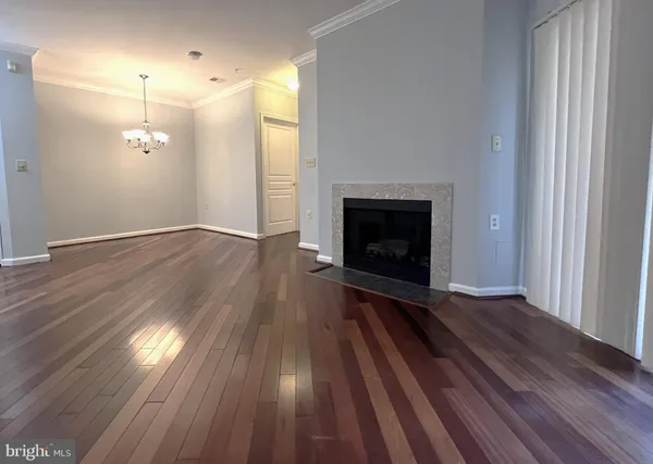 a view of empty room with wooden floor and fireplace