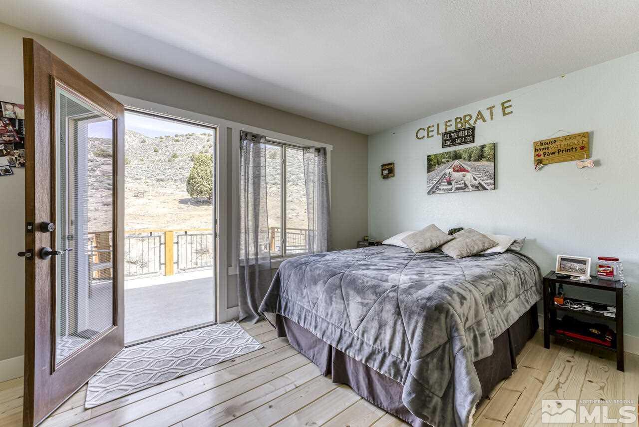 15555 Pyramid Way Reno, NV 89510 - Photo 11 of 39 a bedroom with a bed and a large window with wooden floor