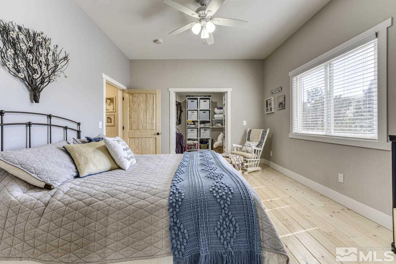 15555 Pyramid Way Reno, NV 89510 - Photo 19 of 39 a bedroom with a large bed and a chandelier