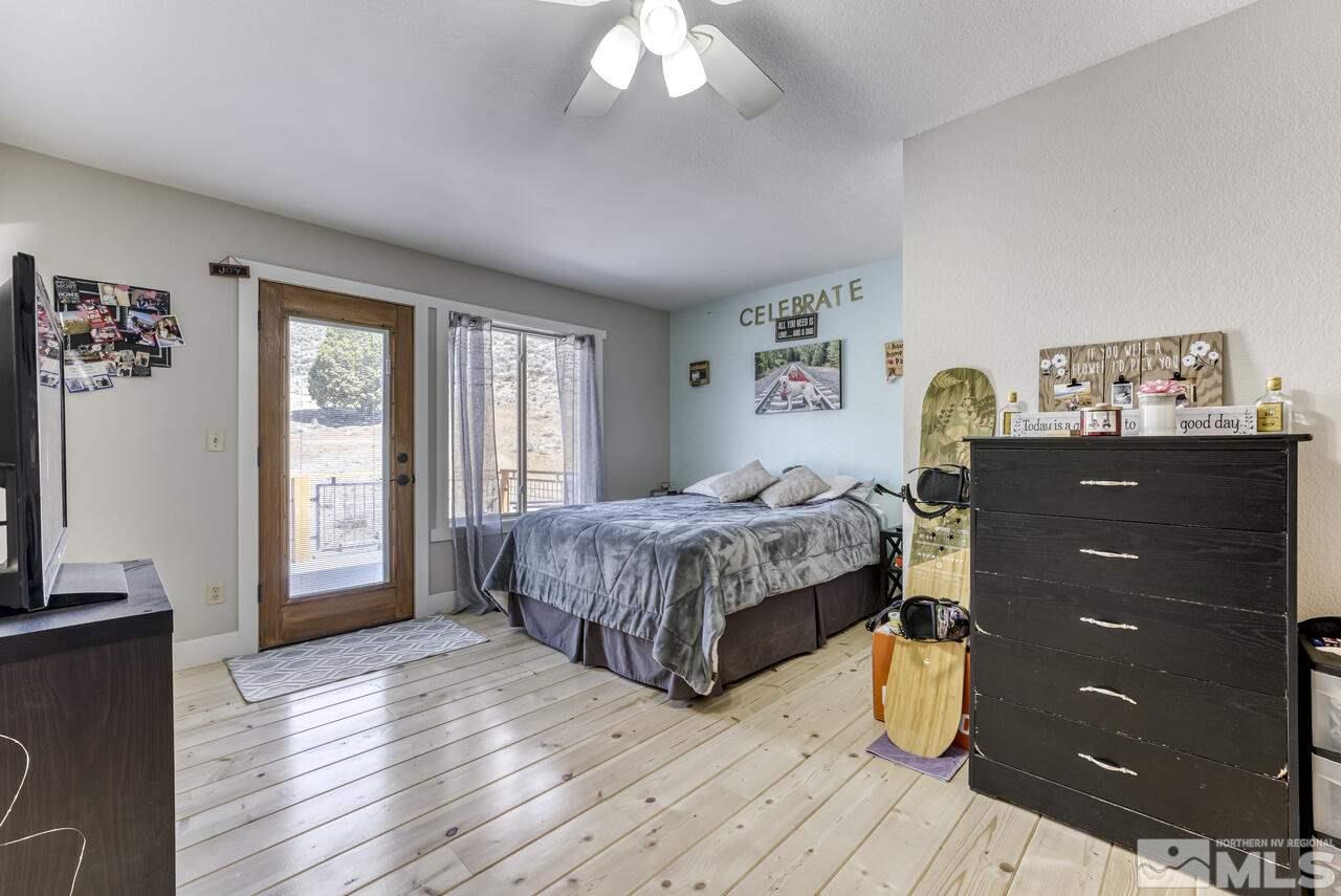 15555 Pyramid Way Reno, NV 89510 - Photo 21 of 39 a bedroom with a bed and a flat tv screen on dresser