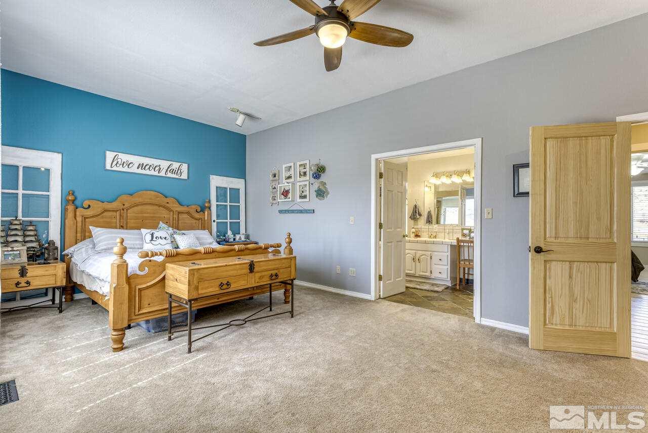 15555 Pyramid Way Reno, NV 89510 - Photo 31 of 39 a bedroom with a bed and a chandelier