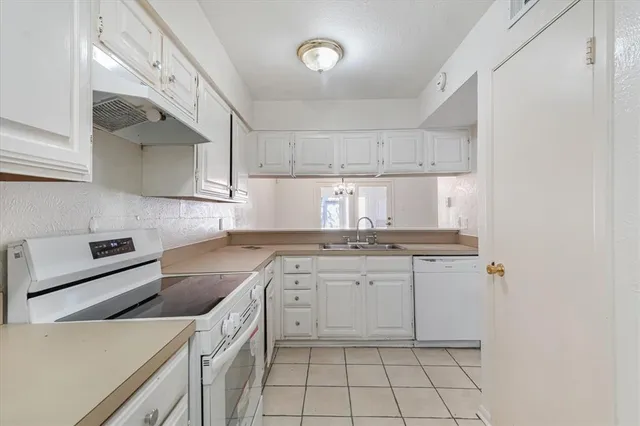 a kitchen with a stove sink and cabinets