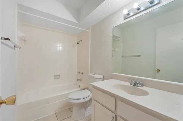 a bathroom with a granite countertop sink a toilet and shower