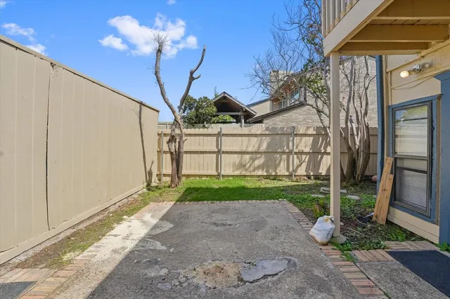 a view of a house with a small yard and wooden fence and floor to ceiling window