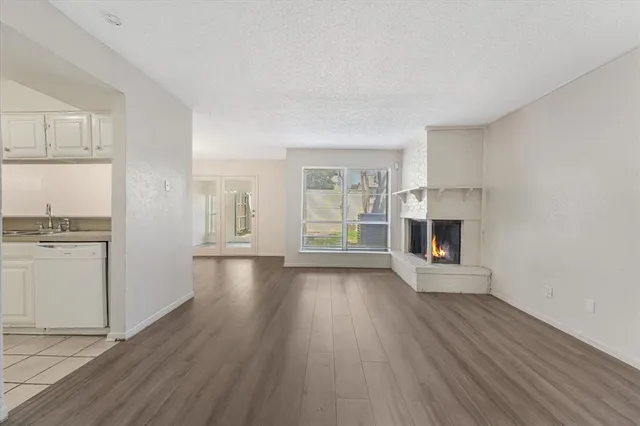 an empty room with wooden floor and fireplace