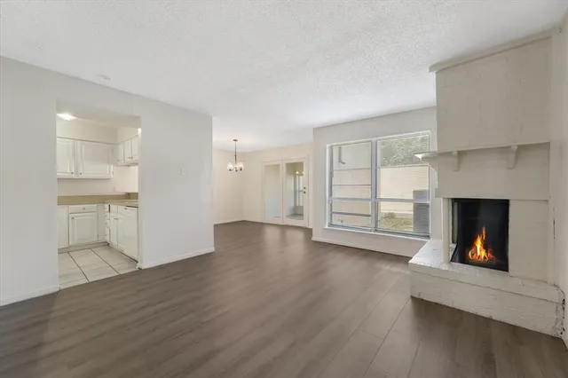 a view of a livingroom with wooden floor and a fireplace