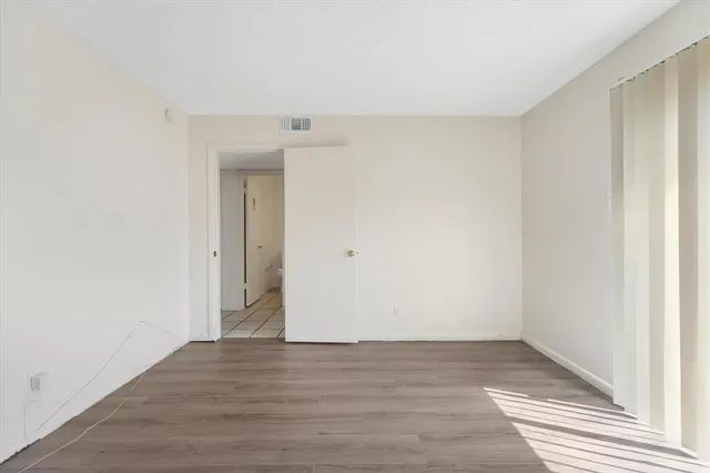 a view of an empty room with wooden floor