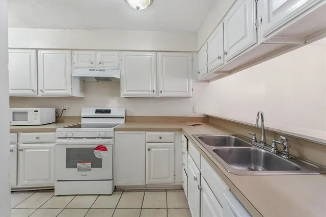 a kitchen with white cabinets sink and white appliances