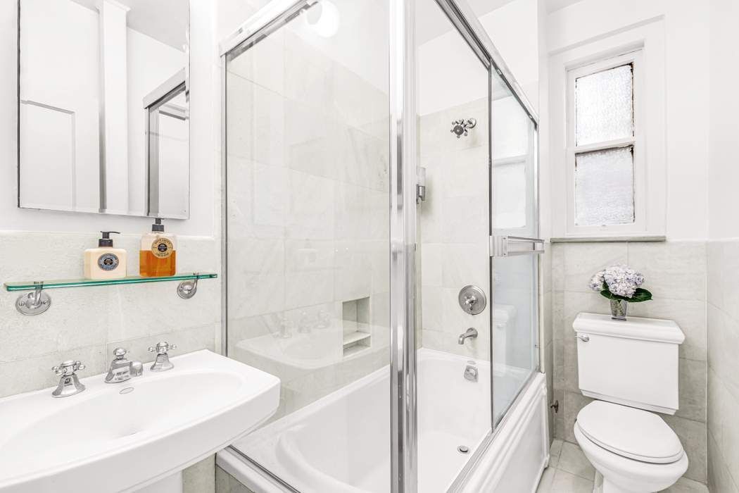 135 East 74th Street, Unit 6C Manhattan, NY 10021 - Photo 6 of 8 a bathroom with a sink toilet and shower