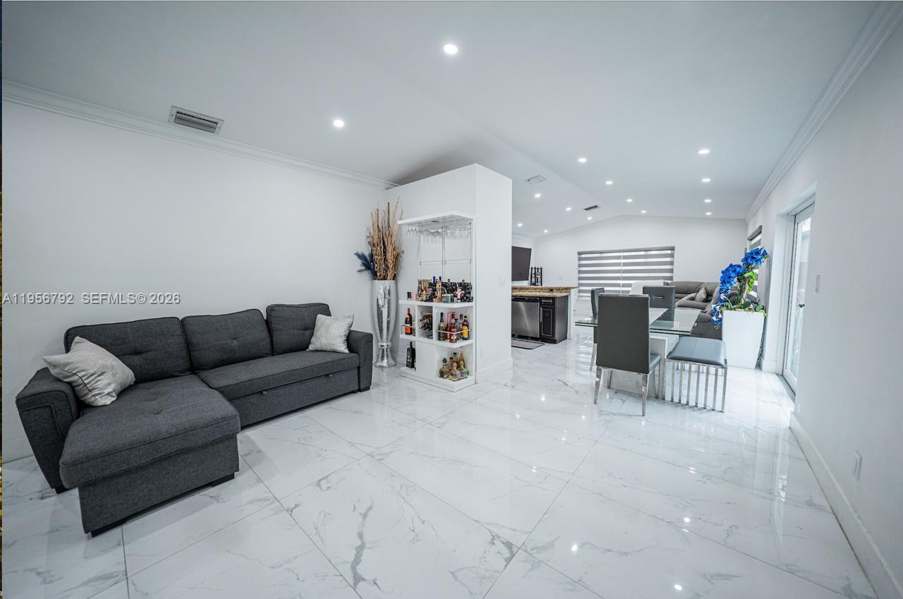 a living room with furniture and kitchen view