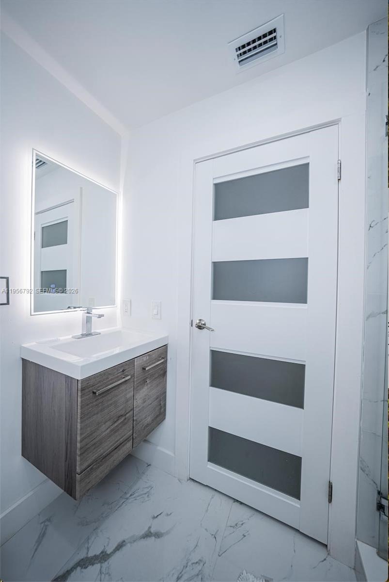 17404 Southwest 142nd Place Miami, FL 33177 - Photo 12 of 29 a bathroom with a double vanity sink and mirror