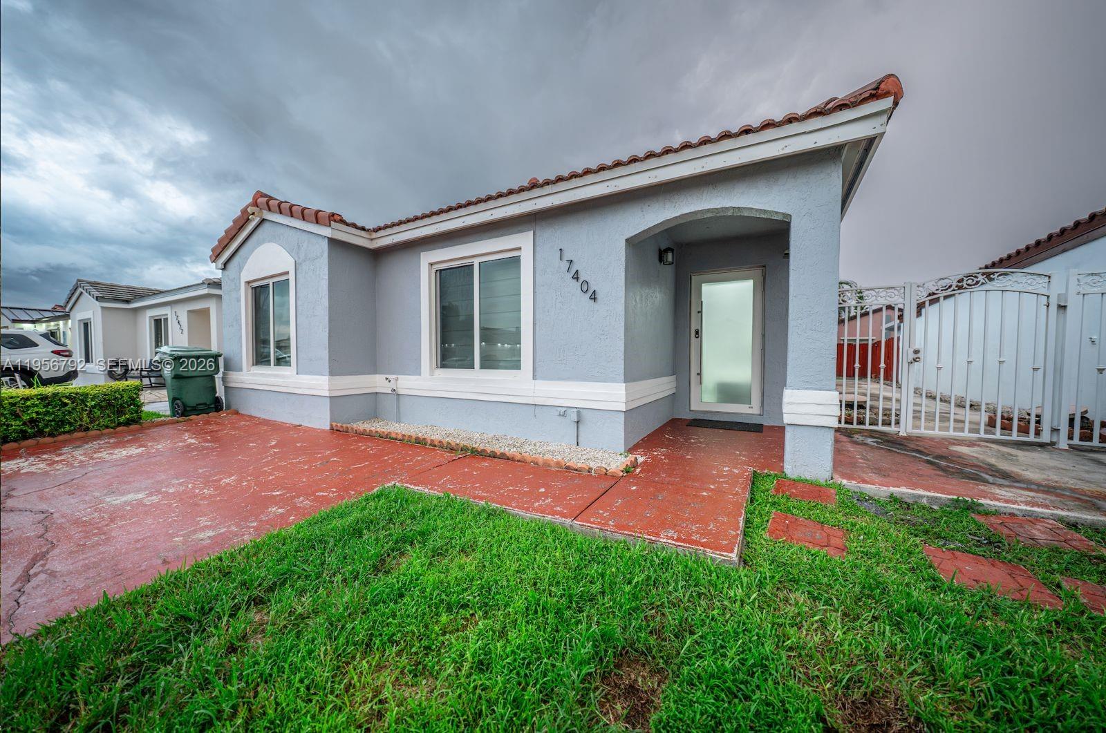 17404 Southwest 142nd Place Miami, FL 33177 - Photo 27 of 29 a front view of a house with a yard and porch