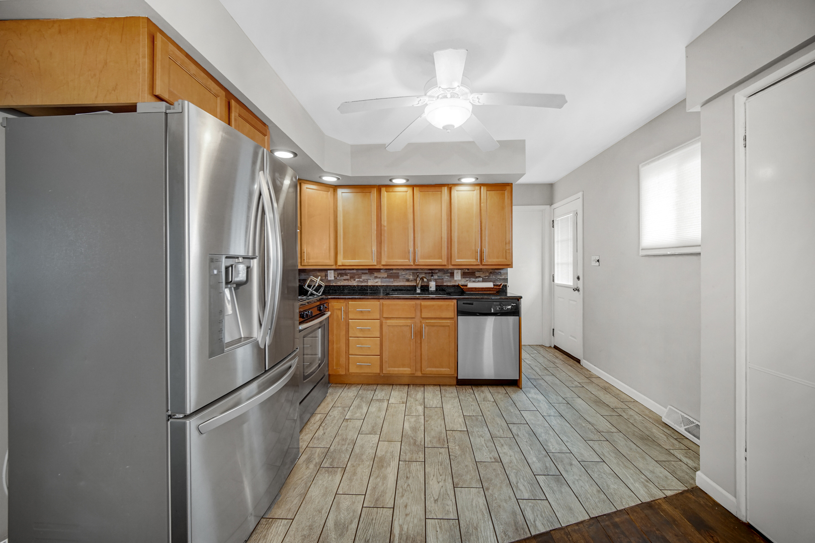 17509 Maple Avenue Lansing, IL 60438 - Photo 4 of 27 a kitchen with a refrigerator a sink and dishwasher with wooden floor